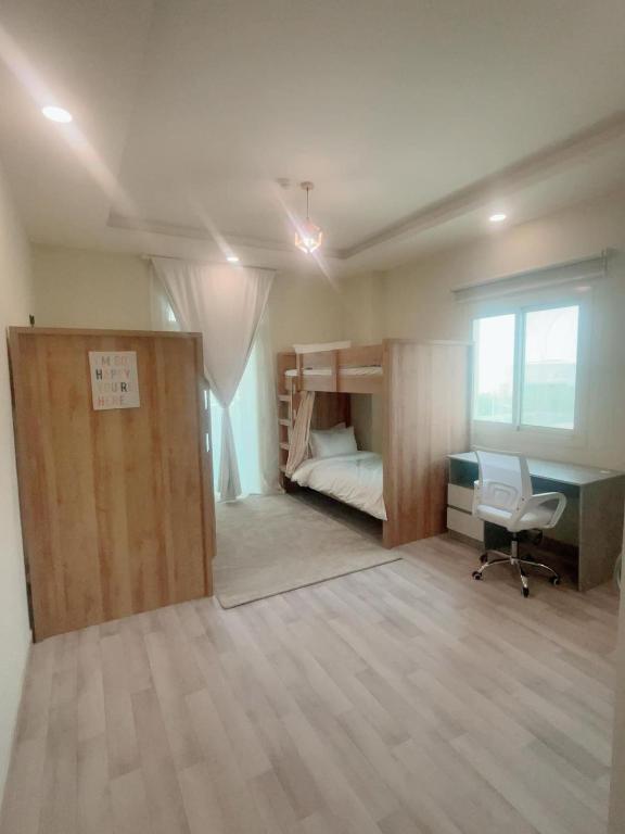 a room with a bunk bed and a desk and a chair at Luxury apartment with balcony, City view in Jeddah