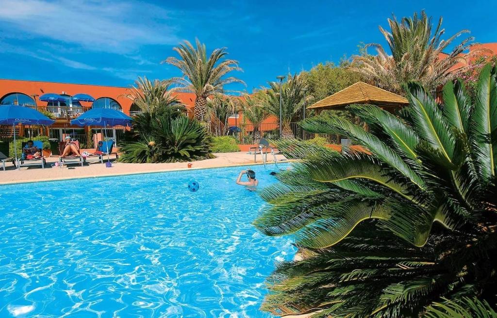 una piscina in un resort con persone che nuotano al suo interno di T2 Cap Agde Terrace Piscine a Cap d'Agde