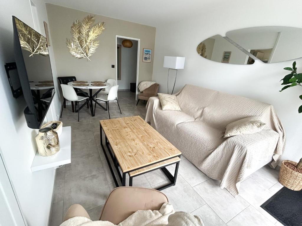 un salon avec un canapé et une table dans l'établissement Charmant cocon avec terrasse en RDC proche plage, à Cabourg