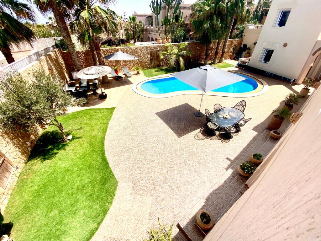 an overhead view of a backyard with a pool and an umbrella at Villa targa in Mirleft