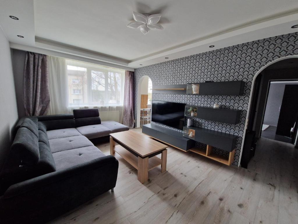 a living room with a couch and a table at Cozy apartment in Ventspils