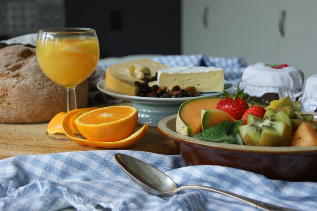 a table with a plate of fruit and a glass of orange juice at Waitapu Springs B&B in Takaka