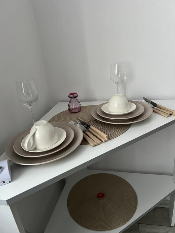 a table with plates and wine glasses on it at Rosu Residence 2 in Onești