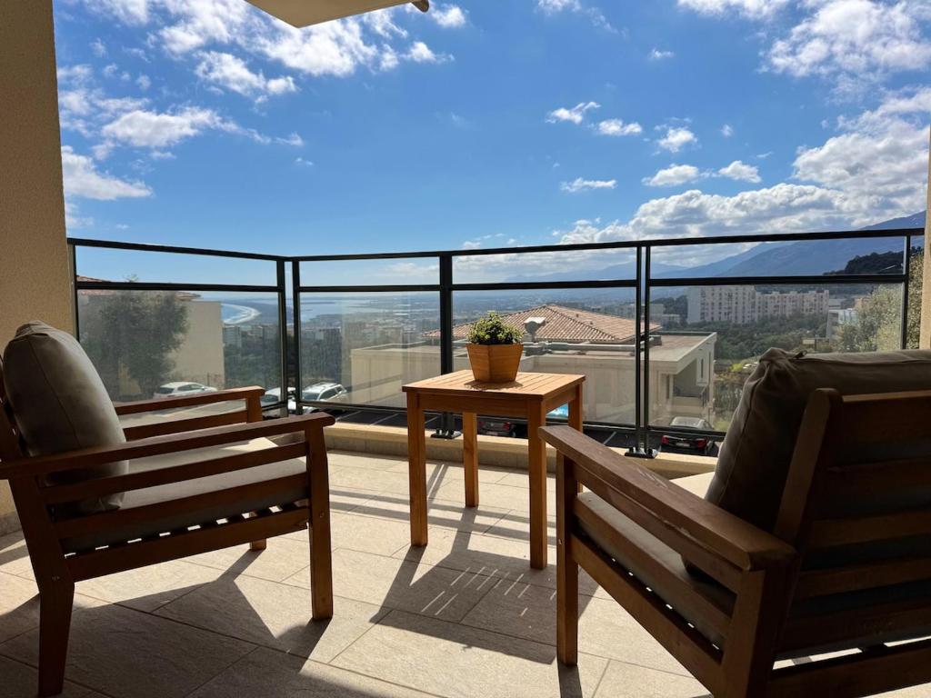 deux chaises et une table sur un balcon avec vue dans l'établissement Charming 2-bedroom with sea and mountain views, à Bastia