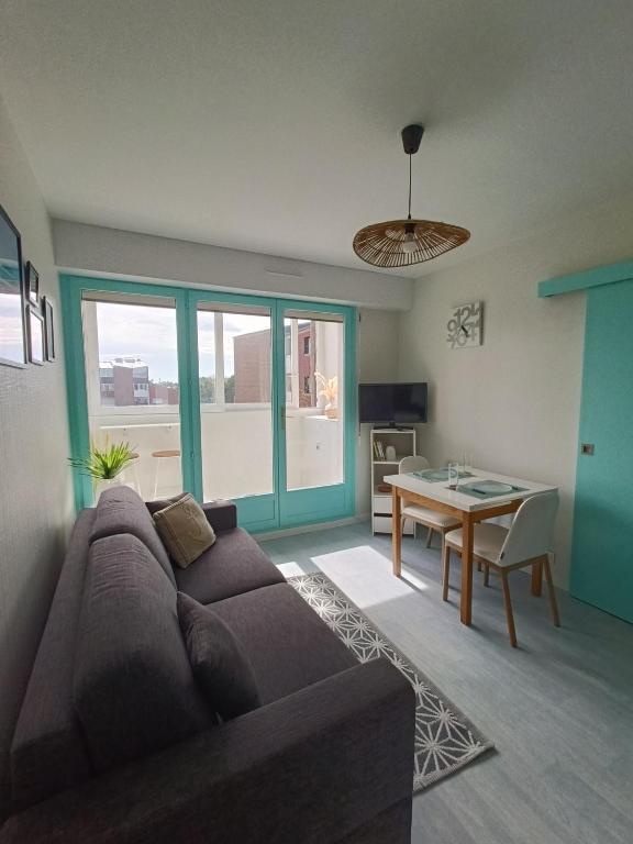 un salon avec un canapé et une table dans l'établissement L'Échappée lumineuse, à Cabourg