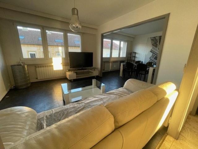 un salon avec un canapé et une télévision à écran plat dans l'établissement Le Graouilly, à Metz