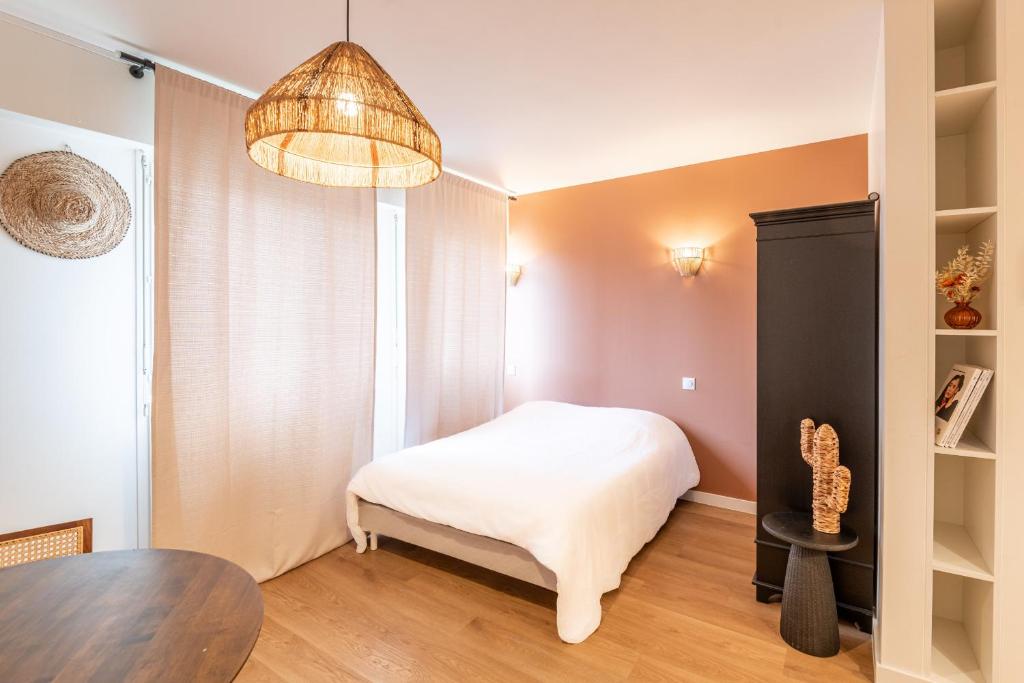 ein kleines Schlafzimmer mit einem Bett und einem Tisch in der Unterkunft M034 Studio bohème centre ville in Annemasse