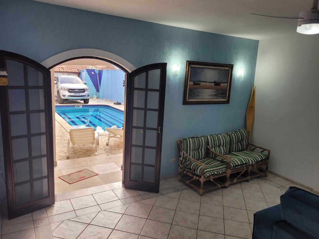 ein Wohnzimmer mit einem Stuhl und einem Pool in der Unterkunft Casa Suarão lazer,espaço área gourmet in Itanhaém