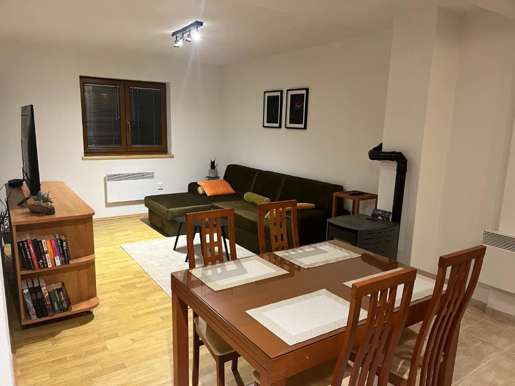 a living room with a table and a couch at Kupres Apartman555 in Kupres