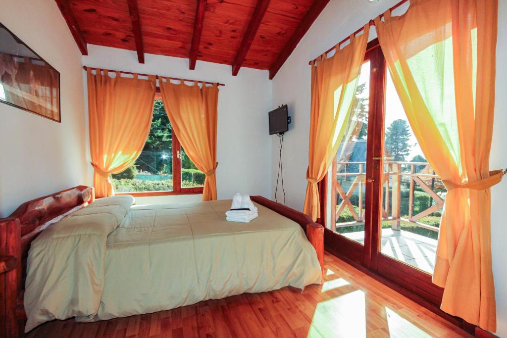 a bedroom with a bed and a large window at Mont Blanc Bungalows in San Carlos de Bariloche