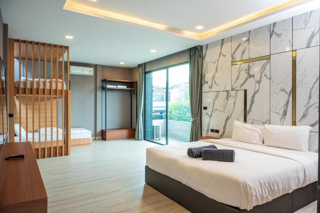 ein Schlafzimmer mit einem großen Bett und einem großen Fenster in der Unterkunft Pool Villa Sura Designer in Nong Prue