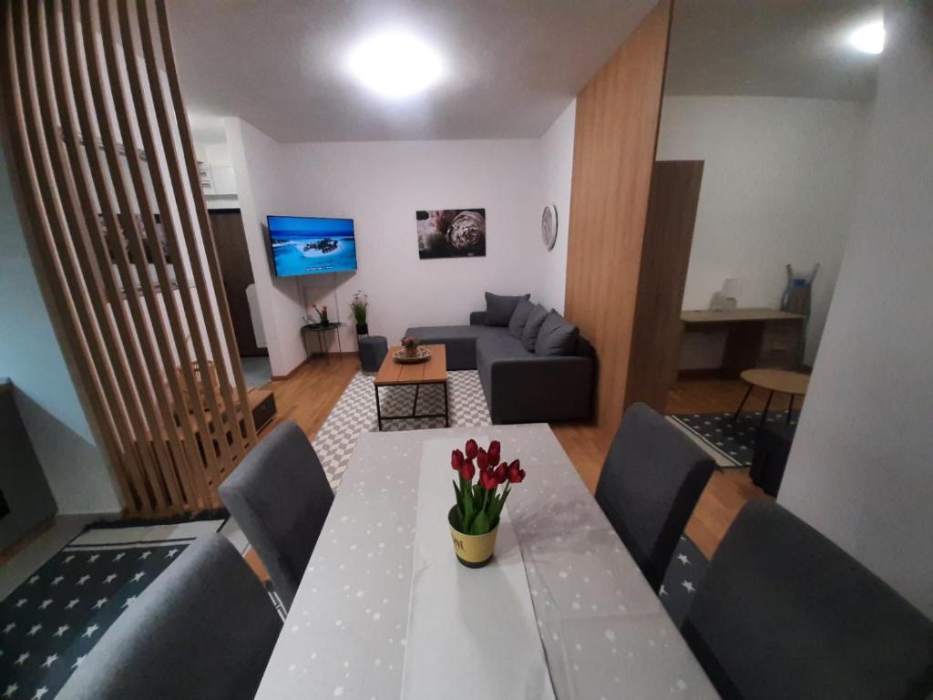a living room with a table and a couch at Apartman Beograd Mir i Komfor in Belgrade