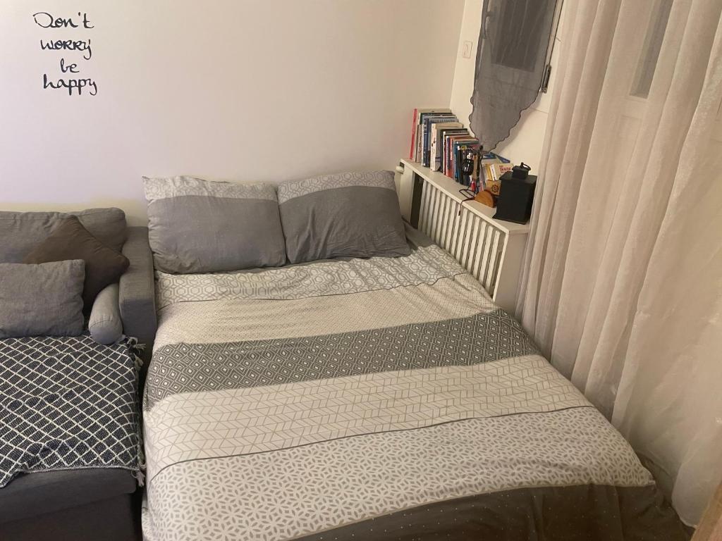 a small bedroom with a bed and a book shelf at Appartement Montrouge in Montrouge