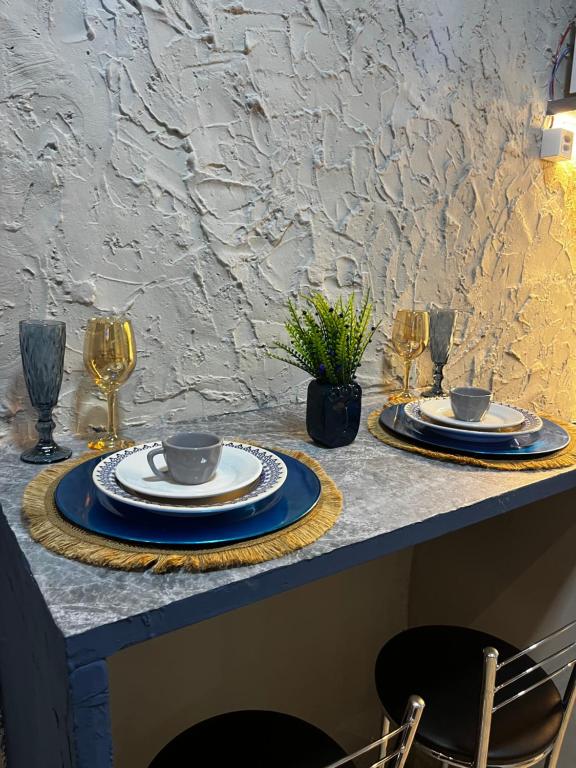 a table with plates and wine glasses on it at É de casa unidade 02 centro in Juazeiro do Norte