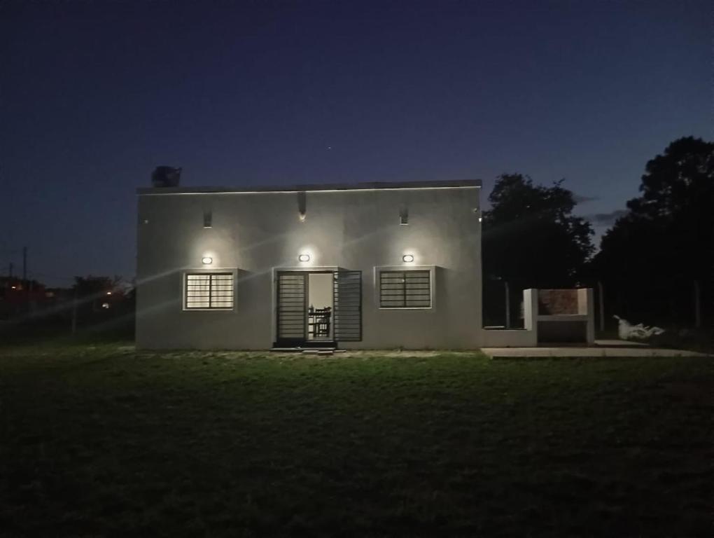 una piccola casa bianca di notte con luci di El Quincho de Ampi a Chascomús