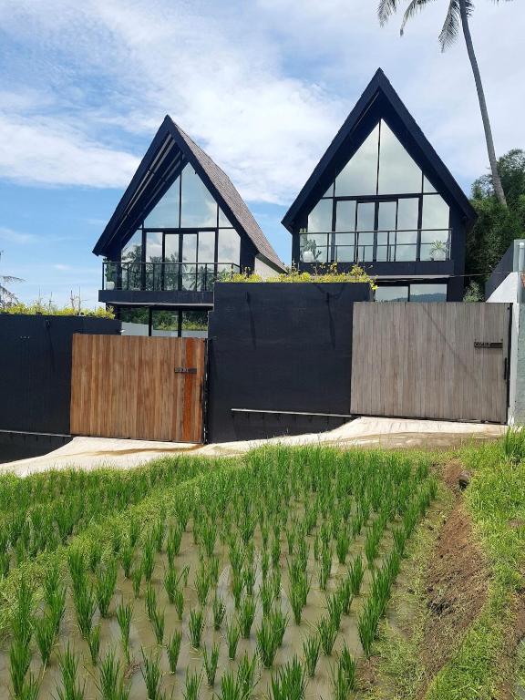 a house with large windows and a field of plants at Villa cecile in Balian