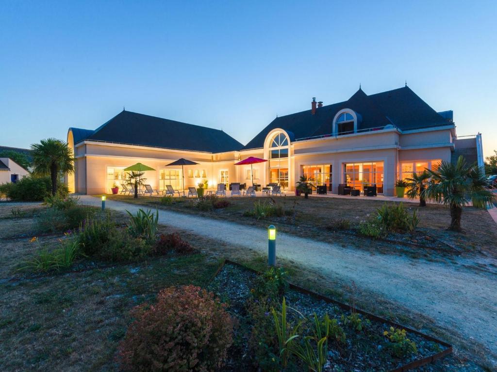 une grande maison avec des lumières devant elle dans l'établissement Terraced Holiday Home in France with Garden, à Azay-le-Rideau