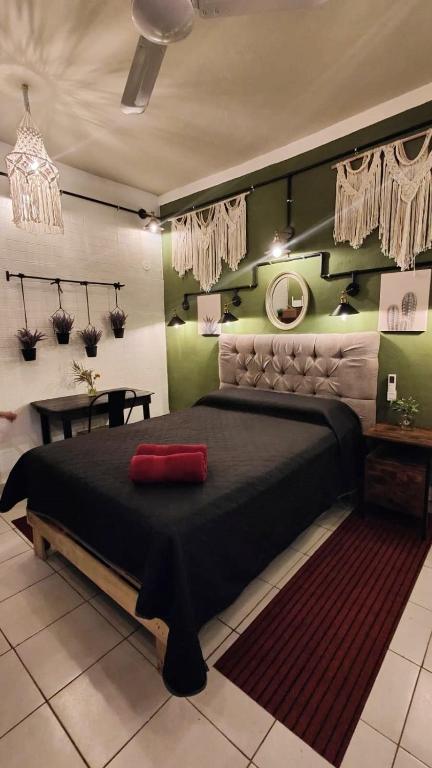 a bedroom with a large bed with a red pillow on it at Frida Downtown Apart in Playa del Carmen
