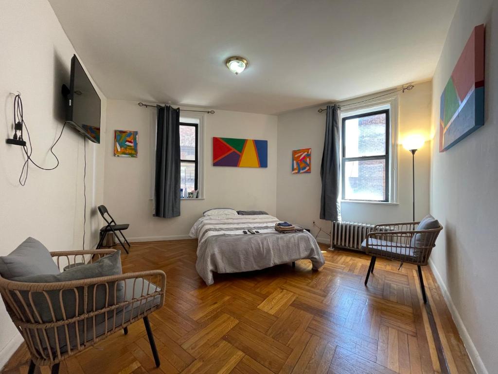a bedroom with a bed and two chairs in it at 2-Bedroom Apartment in the Bronx and Pet Friendly in Bronx