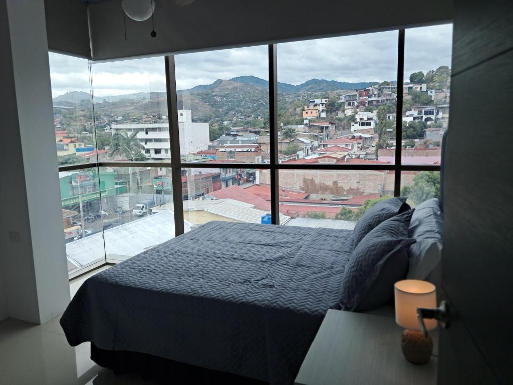 ein Schlafzimmer mit einem Bett und einem großen Fenster in der Unterkunft En el Centro de Matagalpa in Matagalpa