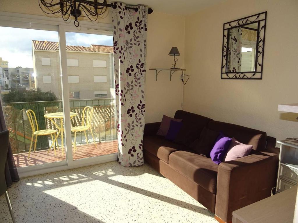 d'un salon avec un canapé et un balcon. dans l'établissement Studio 25m² Climatisé au Cœur de Canet-en-Roussillon - FR-1-833-5, à Canet