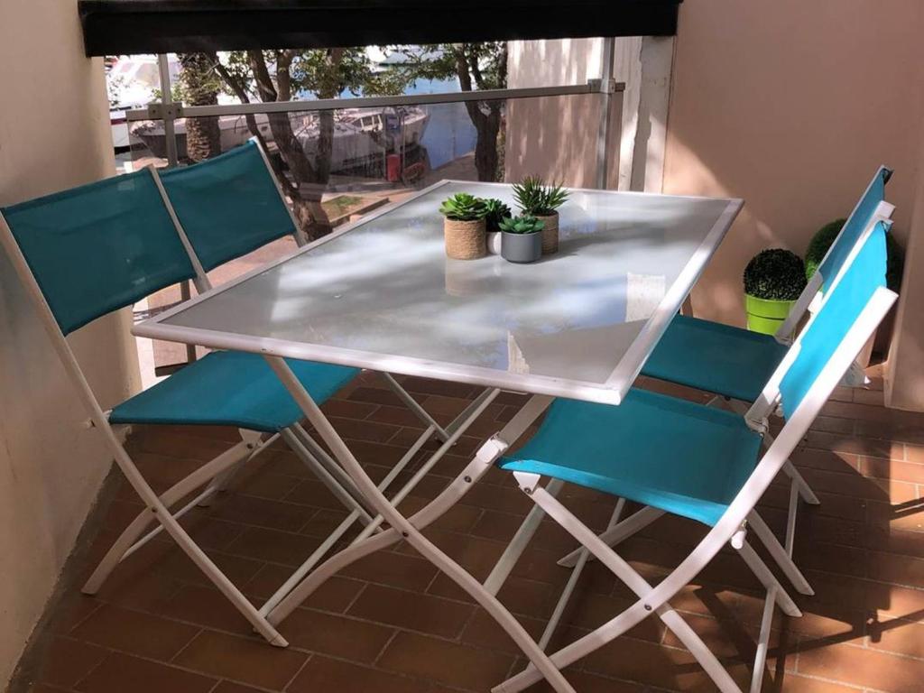 d'une table, de chaises et de plantes sur le balcon. dans l'établissement Studio Cosy avec Balcon, Animaux Acceptés, 4 Pers. - FR-1-833-22, à Canet