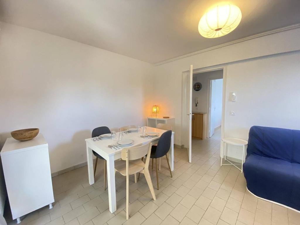 un salon avec une table et un canapé bleu dans l'établissement Appartement 2 pièces climatisé avec WIFI près de la plage - FR-1-833-16, à Canet