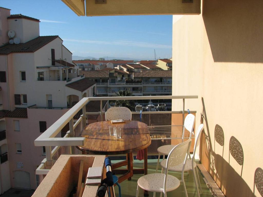 une table et des chaises sur le balcon d'un bâtiment dans l'établissement Studio avec Parking - C 033 - FR-1-833-29, à Canet