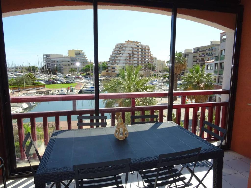 une table sur un balcon avec vue sur un port dans l'établissement Spacieux T3 Traversant au Port à Canet Plage - FR-1-833-32, à Canet