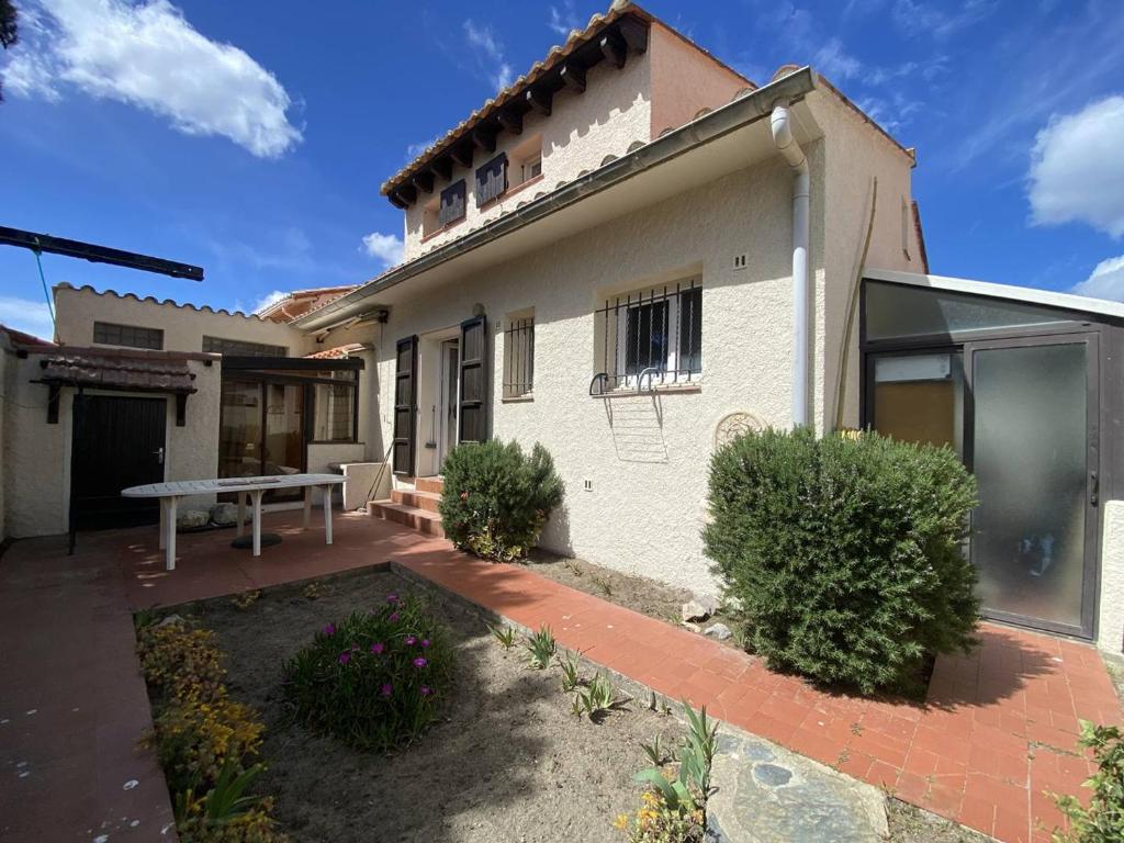 une maison avec une table de pique-nique devant elle dans l'établissement Maison atypique pour 8 pers., animaux acceptés, terrasses - FR-1-833-31, à Canet