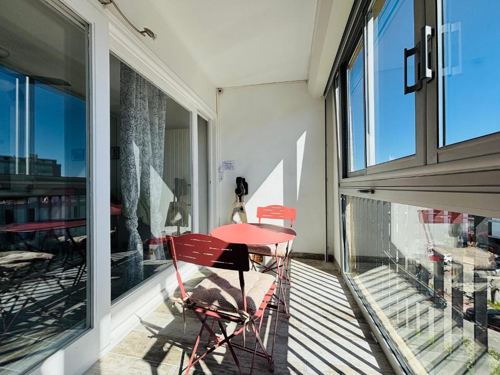 une table et des chaises rouges assises sur un balcon dans l'établissement Saint Cyprien : T2 rénové avec Loggia & Parking privatif - FR-1-309-506, à Saint-Cyprien