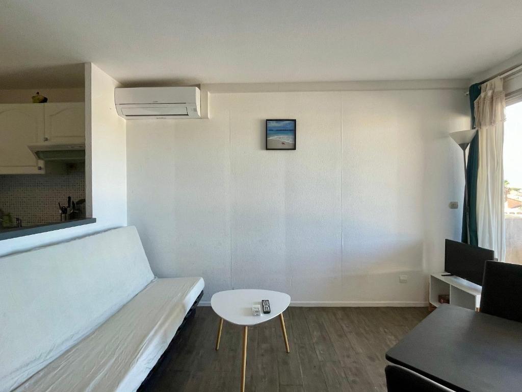 un petit salon avec un canapé et une table dans l'établissement Appartement 2 pièces avec piscine - FR-1-748-30, à Canet