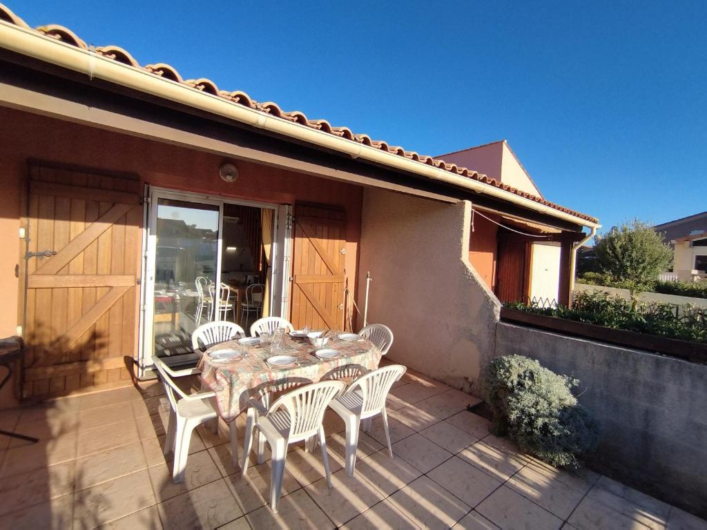 une table et des chaises assises sur une terrasse dans l'établissement Villa T3 Mezzanine - Parking Privé - À 6 min de la plage - 6 pers. - Narbonne-Plage - FR-1-795-62, à Narbonne