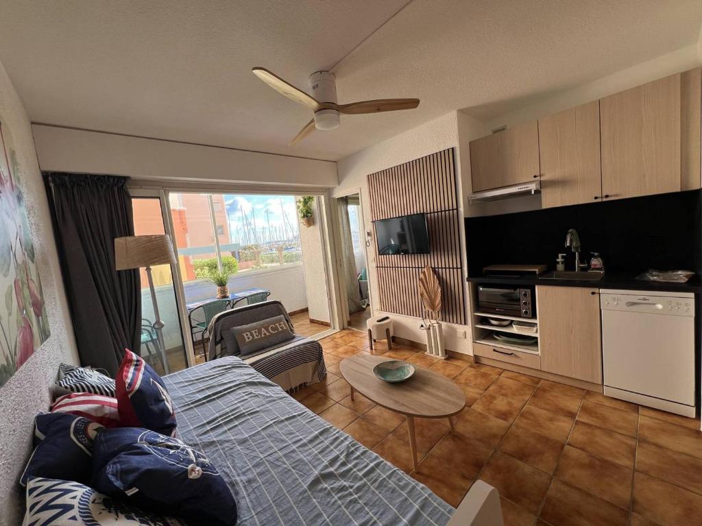 un salon avec un canapé et une table et une cuisine dans l'établissement Appartement 2 pièces avec Parking - 4 personnes, Port Leucate - FR-1-81-637, à Port-Leucate