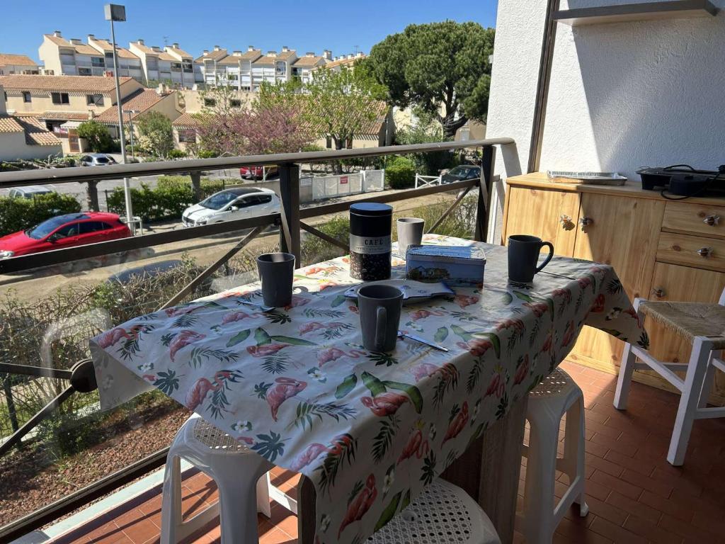 une table sur un balcon avec vue sur une ville dans l'établissement Appartement 2 pièces au Grau-du-Roi avec piscine et parking - FR-1-250-304, au Grau-du-Roi