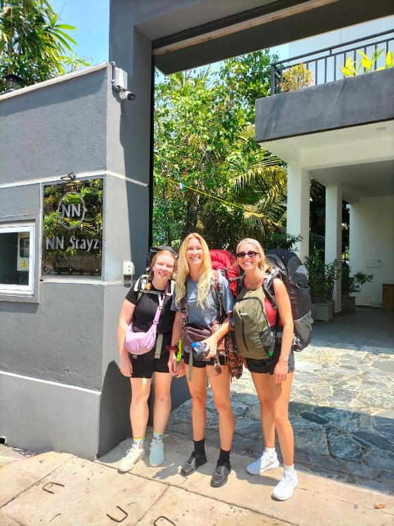 three girls standing outside of a building with their backpacks at NN Stayz in Negombo