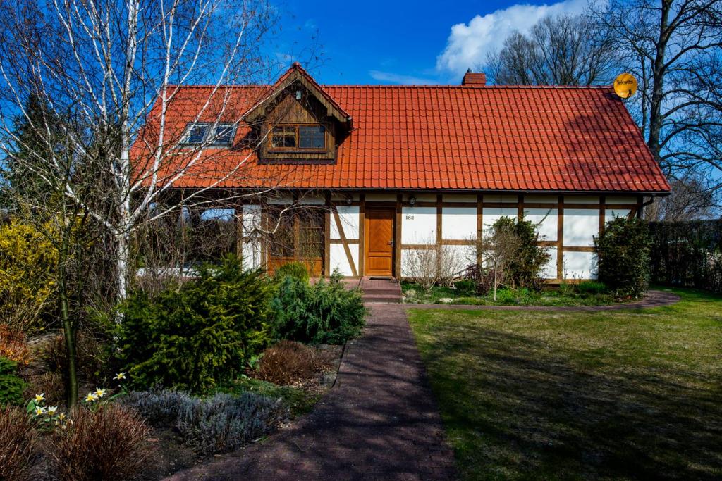 una casa con techo naranja y un camino en Berezecki Family, en Karwieńskie Błoto Drugie