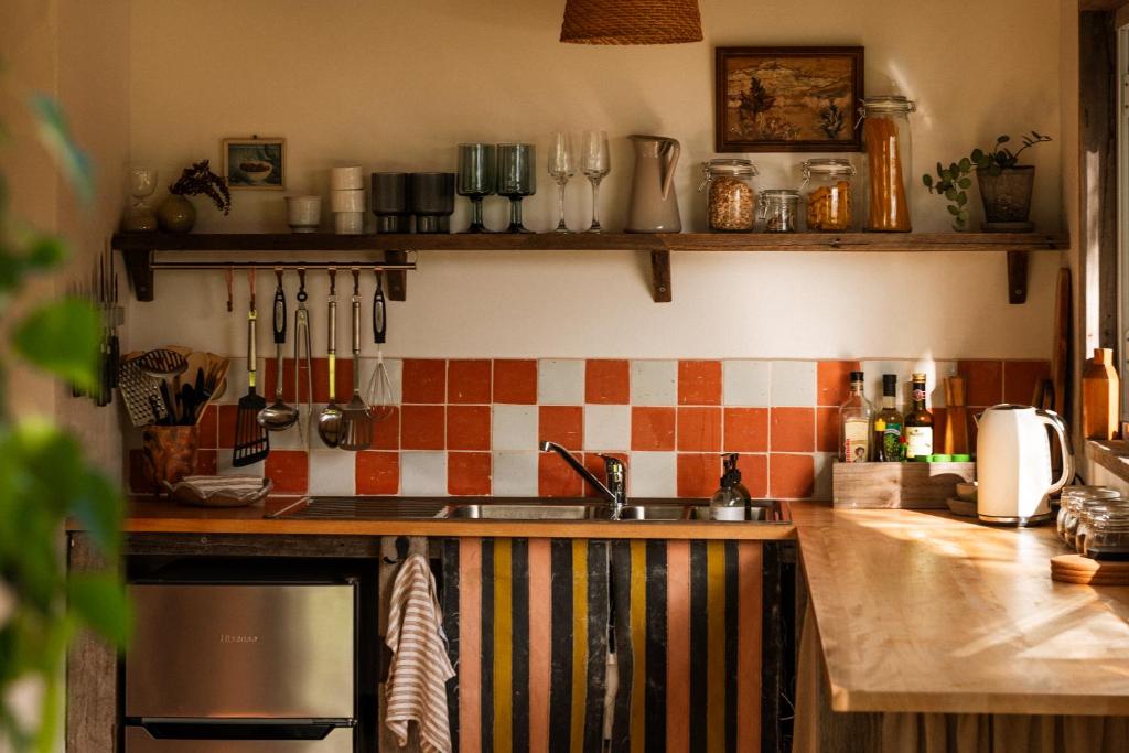 Una cocina con fregadero y azulejos en la pared. en The Casita at La Casa Cubo, en Torquay