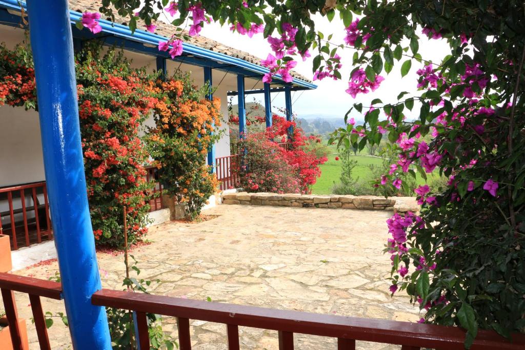 a garden with flowers on a building with a bench at Casa Campestre SUANOGA in Pesca
