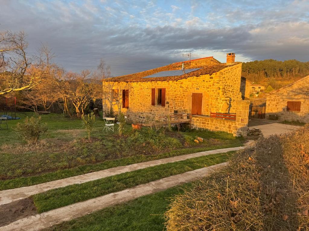 an old brick house in a field with a road at la ferme de la chanvriole in Mercuer