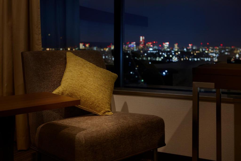 a chair with a pillow in a room with a window at Shin Yokohama Prince Hotel in Yokohama