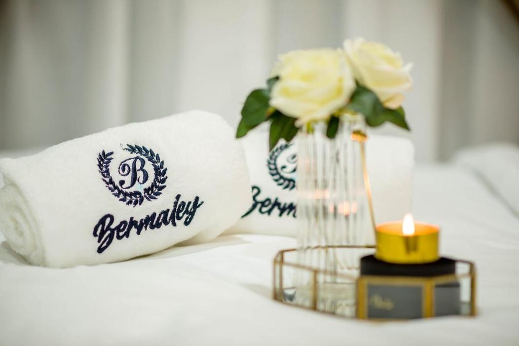 ein Kissen und eine Kerze und eine Vase mit Blumen in der Unterkunft Bermaley Bukit Keluang, Besut in Kampung Raja