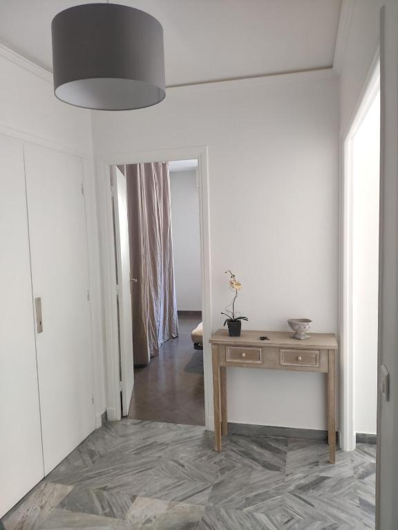 Cette chambre blanche dispose d'une table et d'un miroir. dans l'établissement 3 pièces 67m2 centre ville très lumineux et calme, à Nice