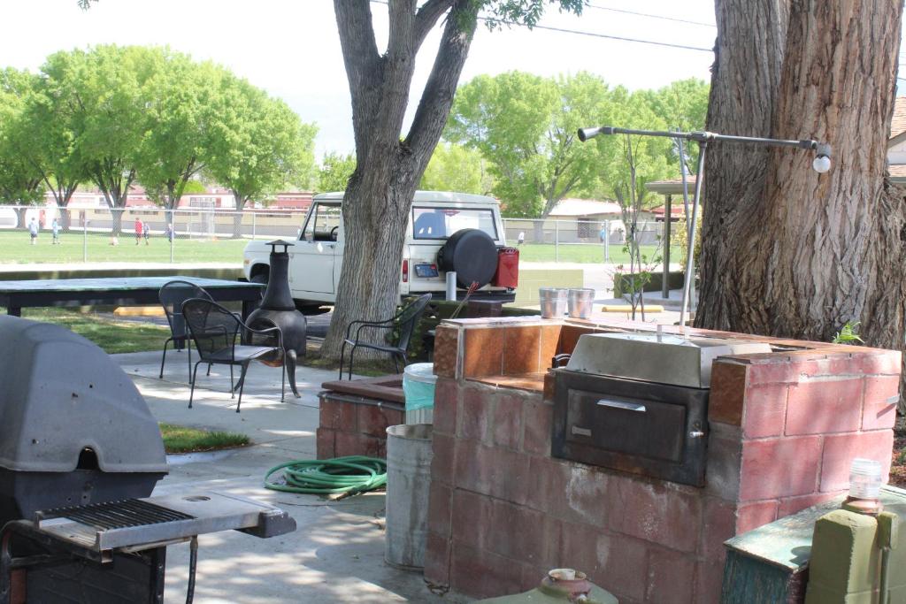 an outdoor grill and smoker next to a tree at Trees Motel in Bishop