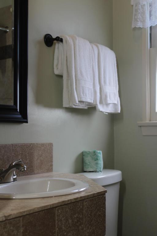 a bathroom with a sink and a toilet and towels at Trees Motel in Bishop