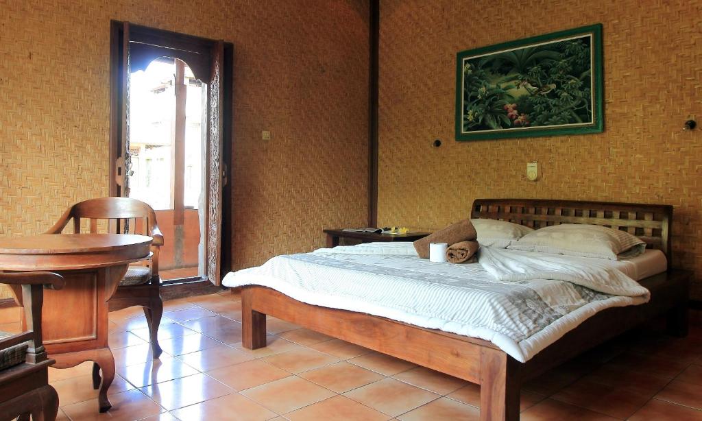 a bedroom with a bed with a teddy bear on it at Bella House Monkey Forest in Ubud