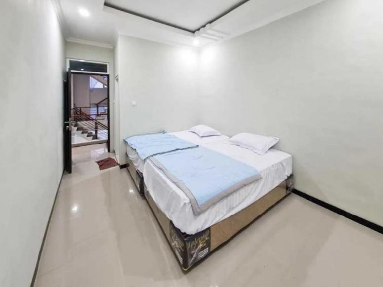 TlekungにあるVilla putih 10 kamarの白い部屋にあるベッドのある寝室
