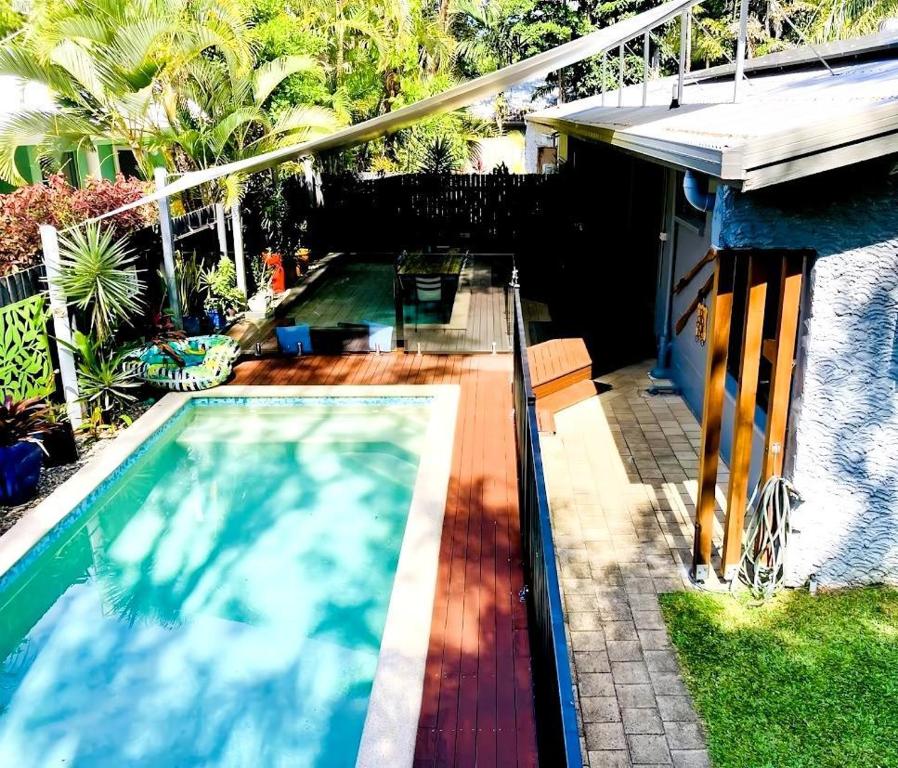 a swimming pool in a yard with a house at Sandy Feet Retreat - 50m from Four Mile Beach in Port Douglas
