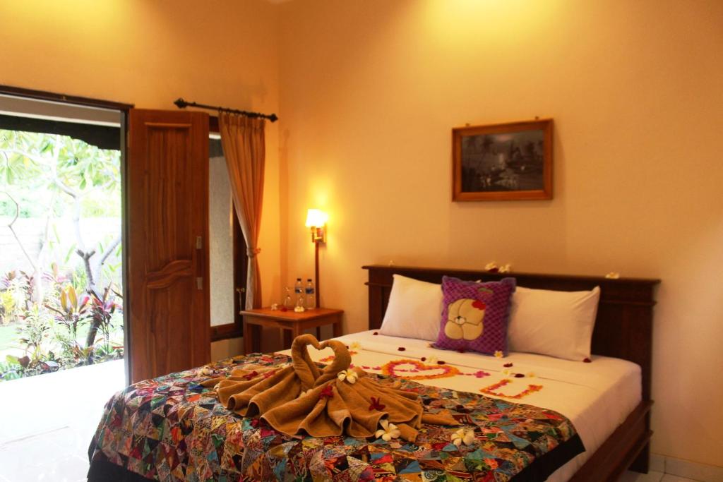 Un dormitorio con una cama con una manta. en Pande Guest House, en Pemuteran