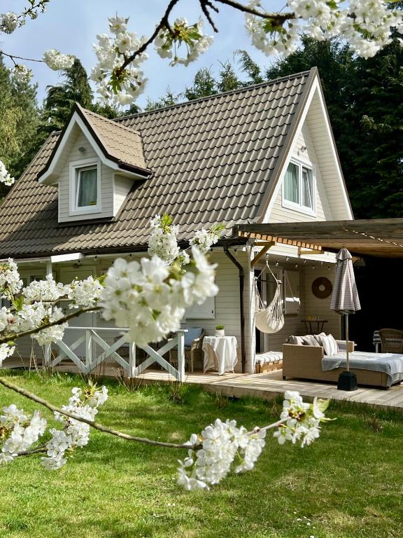 a house with a deck and flowering trees at Harmony House in Wisełka